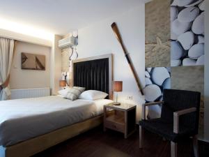 ein Hotelzimmer mit einem Bett und einem Stuhl in der Unterkunft Belle Helene Hotel in Vathy