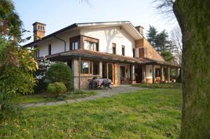 a large white house with a grass yard at Padova Villetta con ampio parco privato in Campodarsego