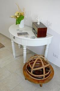 a white table with a basket on the floor and a box on top at Gli Zii di Sicilia in Racalmuto