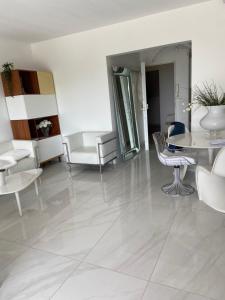 a living room with white furniture and a table and chairs at LA MAISON DE DOMS vue mer in Cassis