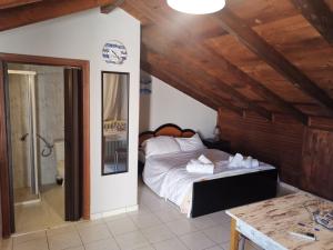 - une chambre avec un lit dans une pièce dotée de plafonds en bois dans l'établissement Lazarus Beach Sofitas, à Monemvasia
