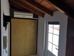 Cette chambre dispose d'une porte, d'un ventilateur et d'une fenêtre. dans l'établissement Lazarus Beach Sofitas, à Monemvasia