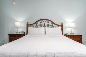 a bedroom with a white bed with two lamps at Beachside Inn in Destin