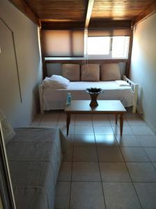 Cette chambre comprend 2 lits et une table. dans l'établissement Lazarus Beach Sofitas, à Monemvasia
