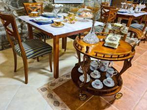 una mesa con platos y tazas en una mesa con sillas en El Molino de la Ropería, en Serrilla
