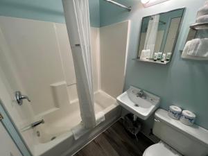 a bathroom with a toilet, sink, and tub at Crow's Nest in Tawas City
