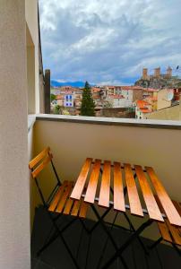 un banc en bois assis sur un balcon avec vue dans l'établissement LOFT et SPA sous les étoiles, à Foix