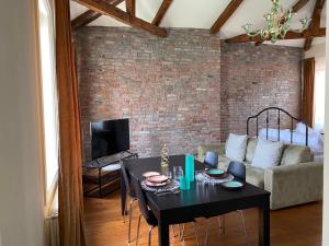 uma sala de estar com uma mesa preta e uma parede de tijolos em DUOMO Murano Apartment with Canal view em Murano