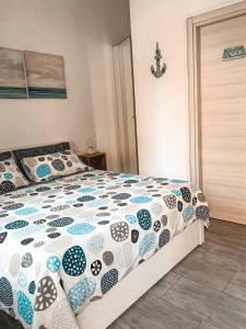 a bedroom with a bed with a blue and white comforter at ACHILLE in Porto Recanati