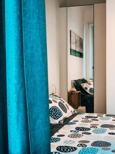 a bedroom with blue curtains and a bed with a mirror at ACHILLE in Porto Recanati