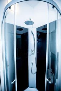 uma casa de banho com um chuveiro e um espelho. em Agréable chambre sur liège avc parking et wifi gratuit em Liège