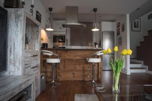 a kitchen with a table with yellow flowers in a vase at EL PATIO DE MI CASA in Avila +14 photos