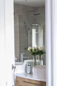 a bathroom with two sinks and a shower with flowers at EL PATIO DE MI CASA in Avila