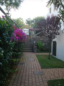 uma passarela de tijolos que leva a uma casa com flores em Islantilla Bajo con Jardin na Islantilla