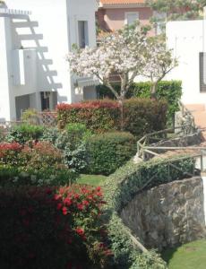 un jardín con flores y árboles y un edificio en Islantilla Bajo con Jardin, en Islantilla