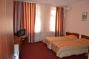 Habitación de hotel con cama y TV en Bulak Hotel, en Kazán