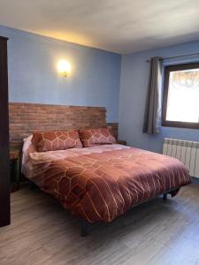 a bedroom with a large bed with a brick wall at Casa Rural La Colmena in Condemios de Abajo