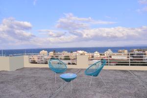 two blue chairs sitting on top of a balcony at Panoramic Penthouse in Chios