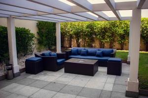 un patio con muebles azules bajo una pérgola en Delmond Hotel, en Cuiabá