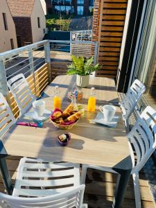 una mesa de madera con un bol de fruta en el balcón en Le Foxtrot à 50m du centre historique, en Sarlat-la-Canéda