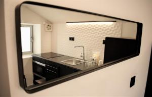 a mirror reflection of a bathroom with a sink at Fisherman's Albufeira Cosy Studio in Albufeira +5 photos