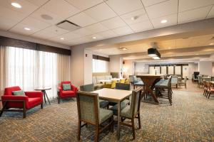 a waiting room with tables and chairs and a classroom at Hampton Inn Buffalo - Amherst in Amherst
