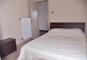 a bedroom with a white bed and a wooden dresser at Panoramic Penthouse in Chios