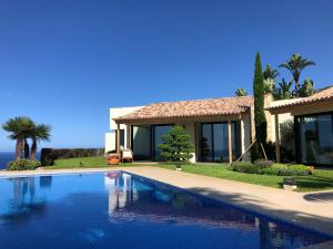 a swimming pool in front of a house at Morning Star Villa in Arco da Calheta
