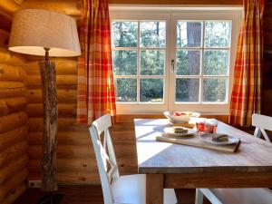 a dining room with a wooden table with a lamp at Scandinavian Lodges (by Outdoors Holten) in Holten