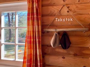 a log cabin with a window and a sign that says tucksoxin at Scandinavian Lodges (by Outdoors Holten) in Holten