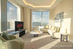 a living room with a couch and a tv at LUX Iconic Views at The Palm Tower Suite 2 in Dubai