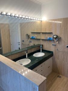 a bathroom with two sinks and a large mirror at Hotel La Muralla in Zafra