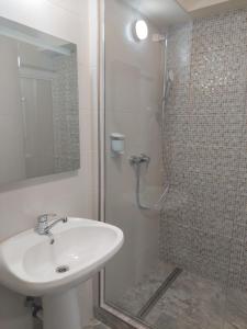 a white bathroom with a sink and a shower at Hotel Breaza in Breaza