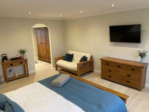 a bedroom with a bed and a chair and a television at Executive home with plenty of room in Ely