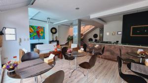 una habitación con mesas, sillas y un escenario en Habitat Suites Hotel, en Pereira