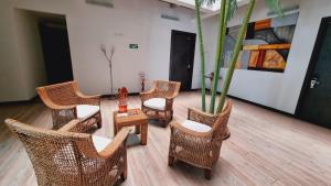Habitación con sillas de mimbre y maceta en Habitat Suites Hotel, en Pereira