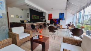 un vestíbulo con sillas y mesas y un bar en Habitat Suites Hotel, en Pereira 37 fotos más