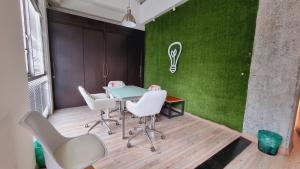 una mesa y sillas en una habitación con una pared verde en Habitat Suites Hotel, en Pereira
