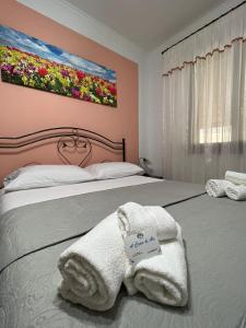 1 dormitorio con 2 camas, toallas y un cuadro en la pared en a casa di Ale, en Santa Maria di Castellabate
