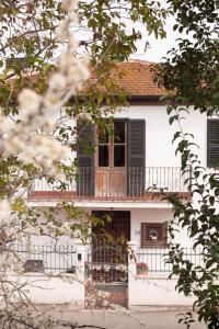 Casa blanca con balcón en la parte superior. en Casale delle Rondini, en Notaresco