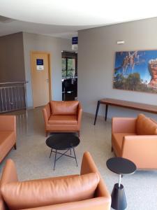 une salle d'attente avec des meubles en cuir et une table dans l'établissement Hotelog Tibagi, à Ponta Grossa