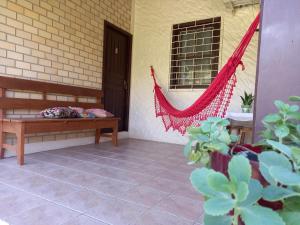 a hammock on the porch of a house at Morada Caminho do Mar in Praia do Rosa