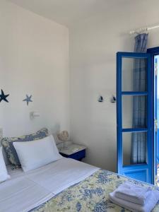 1 dormitorio con 1 cama y puerta azul en Cavos Studio by the sea (West) en Drios