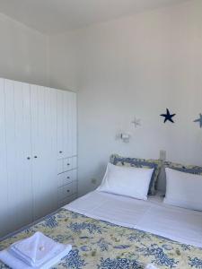 a bedroom with a bed with white sheets and stars on the wall at Cavos Studio by the sea (West) in Drios