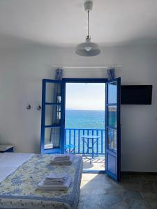 a bedroom with a bed and a view of the ocean at Cavos Studio by the sea (West) in Drios