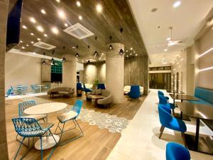 a lobby with blue chairs and tables in a building at Fairways and Bluewater Boracay in Boracay