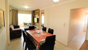 ein Wohnzimmer mit einem Esstisch und ein Wohnzimmer mit einem Tisch in der Unterkunft 1024 - Apartamento em Bombinhas para locação de temporada - Praia de Bombas in Bombas