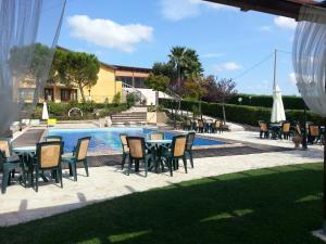 eine Terrasse mit Tischen und Stühlen neben einem Pool in der Unterkunft Al Settimo Cielo in Montenero di Bisaccia