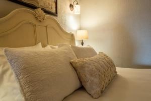 een bed met een witte sprei en een kussen bij 5 Ojo Inn Bed and Breakfast in Eureka Springs