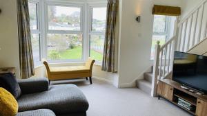 a living room with a couch and a television at Old Quay House - Views of Coronation Park and River Dart in Dartmouth